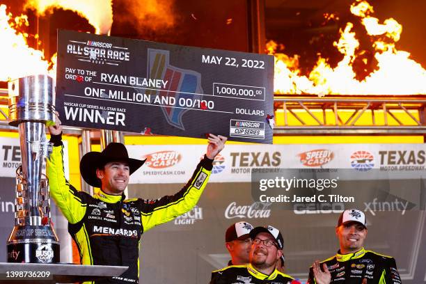 Ryan Blaney, driver of the Menards/Wrangler Ford, celebrates with the million dollar check in victory lane after winning the NASCAR Cup Series...