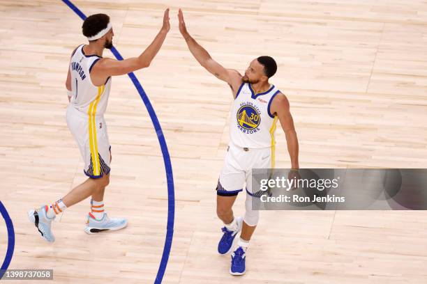 Stephen Curry and Klay Thompson of the Golden State Warriors celebrate a dunk by Thompson during the third quarter against the Dallas Mavericks in...