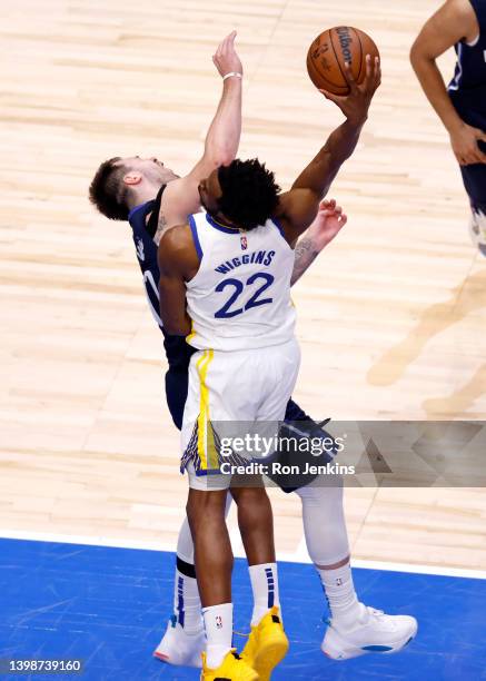 Andrew Wiggins of the Golden State Warriors dunks the ball against Luka Doncic of the Dallas Mavericks during the fourth quarter in Game Three of the...