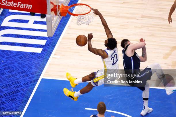 Andrew Wiggins of the Golden State Warriors dunks the ball against Luka Doncic of the Dallas Mavericks during the fourth quarter in Game Three of the...