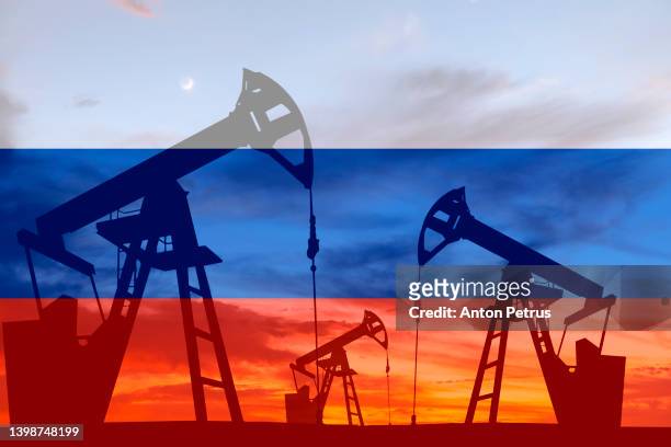 oil pump on the background of of the russian flag - oil pump stockfoto's en -beelden