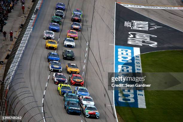 Kyle Busch, driver of the M&M's Crunchy Cookie Toyota, and Ross Chastain, driver of the Worldwide Express Chevrolet, lead the field during the NASCAR...