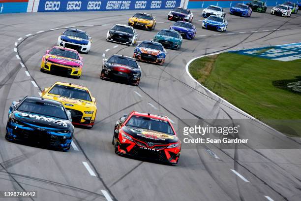 Ross Chastain, driver of the Worldwide Express Chevrolet, and Martin Truex Jr., driver of the Bass Pro Shops Toyota, race during the NASCAR Cup...