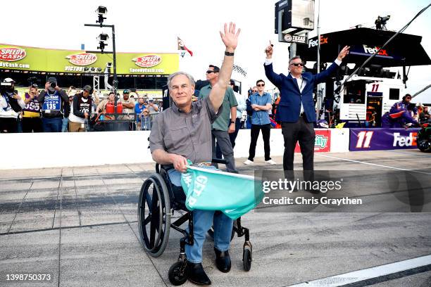 Greg Abbott, governor of Texas waves to NASCAR fans after waving the green flag to start the NASCAR Cup Series All-Star Race at Texas Motor Speedway...