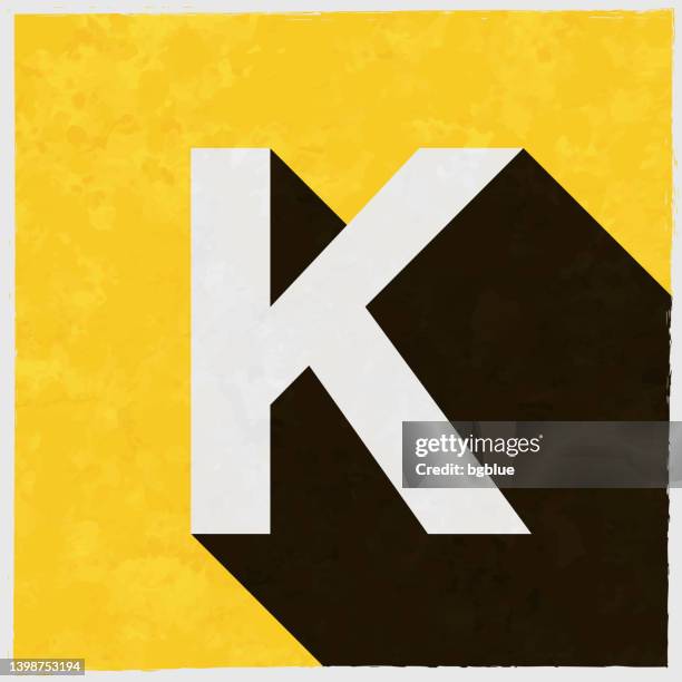 letter k. icon with long shadow on textured yellow background - letter k stock illustrations