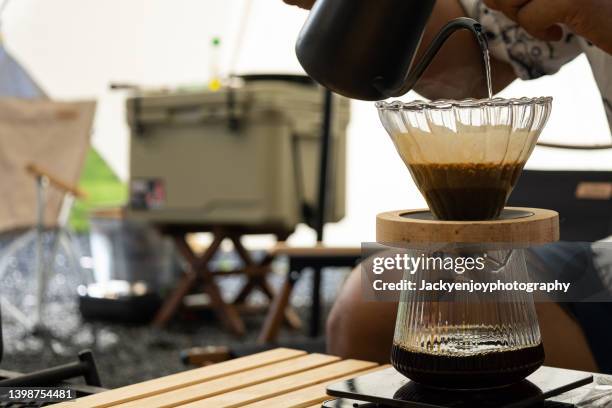 crop man making fresh espresso coffee in front the tent in morning - filterkaffee stock-fotos und bilder