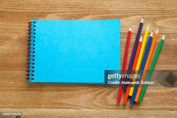 markers and an open blank drawing pad. bright colored pencils are lying on the table next to him. children's creativity, hobbies, school and preschool education. drawing lessons. back to school. - sketch pad stock pictures, royalty-free photos & images
