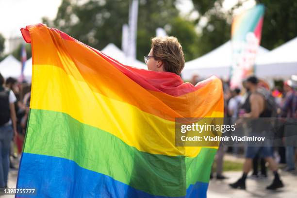 schwuler mann mit großer pride-flagge - gender fluid stock-fotos und bilder