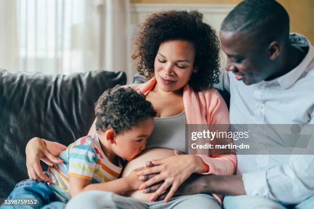 pregnant woman with husband and son at home - black mother stock pictures, royalty-free photos & images