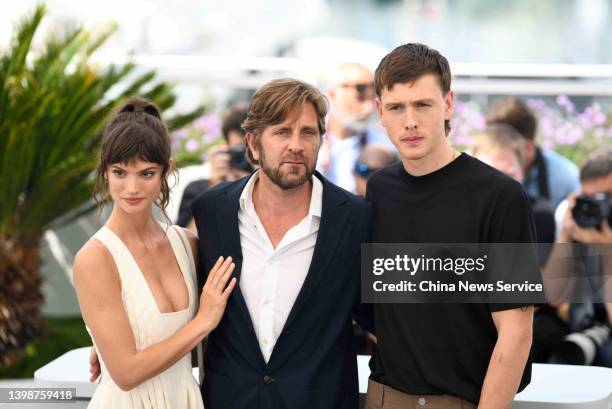 Actress Charlbi Dean Kriek, director Ruben Ostlund and actor Harris Dickinson attend the photocall for "Triangle Of Sadness" during the 75th annual...