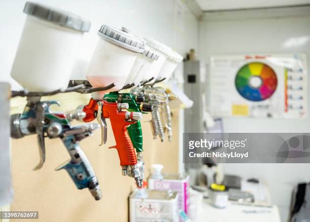 set of automobile paint spray guns hanging on rack - enamel stockfoto's en -beelden