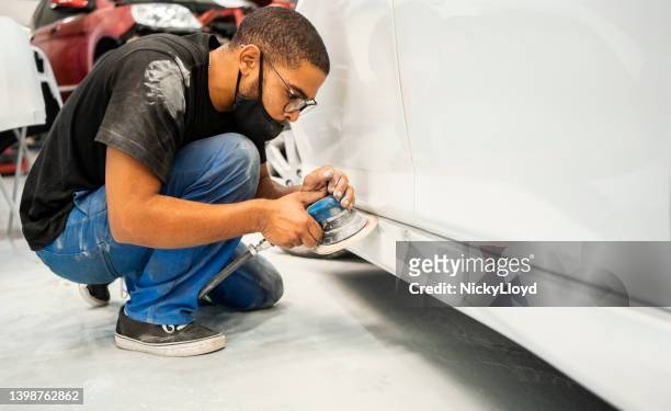mecánico lijando panel basculante de un coche en taller - abollado fotografías e imágenes de stock
