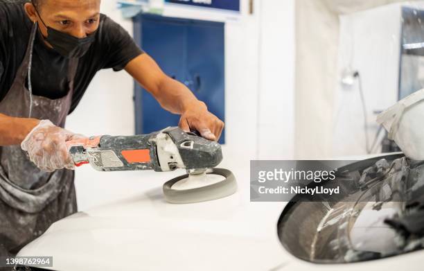 technician using grinding machine to peel off old paint from car hood - car deuk stockfoto's en -beelden