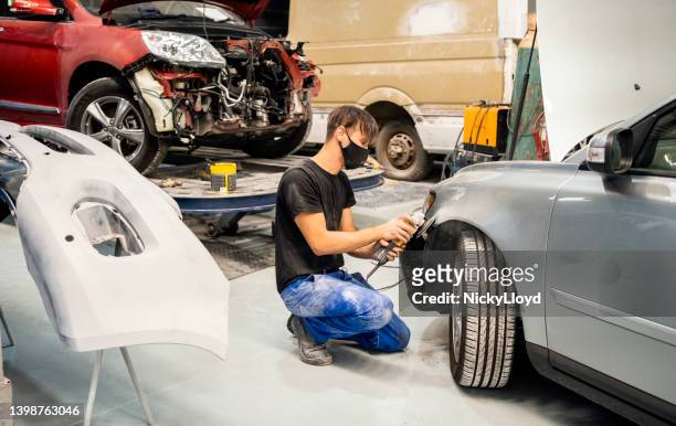 mechanic repairing dent on a car at garage - surface preparation stock pictures, royalty-free photos & images