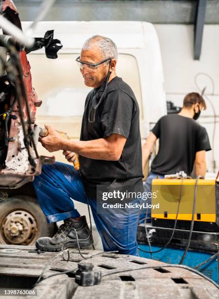 professional repairman working on a car body at garage - rusty old car stock pictures, royalty-free photos & images