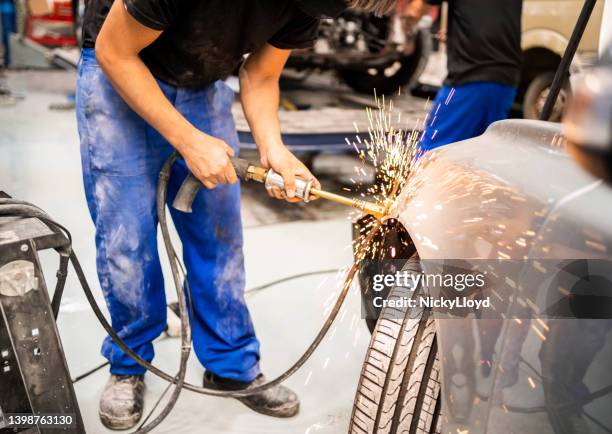 mechanic peening car with tool for removing dents - karosseriarbete bildbanksfoton och bilder