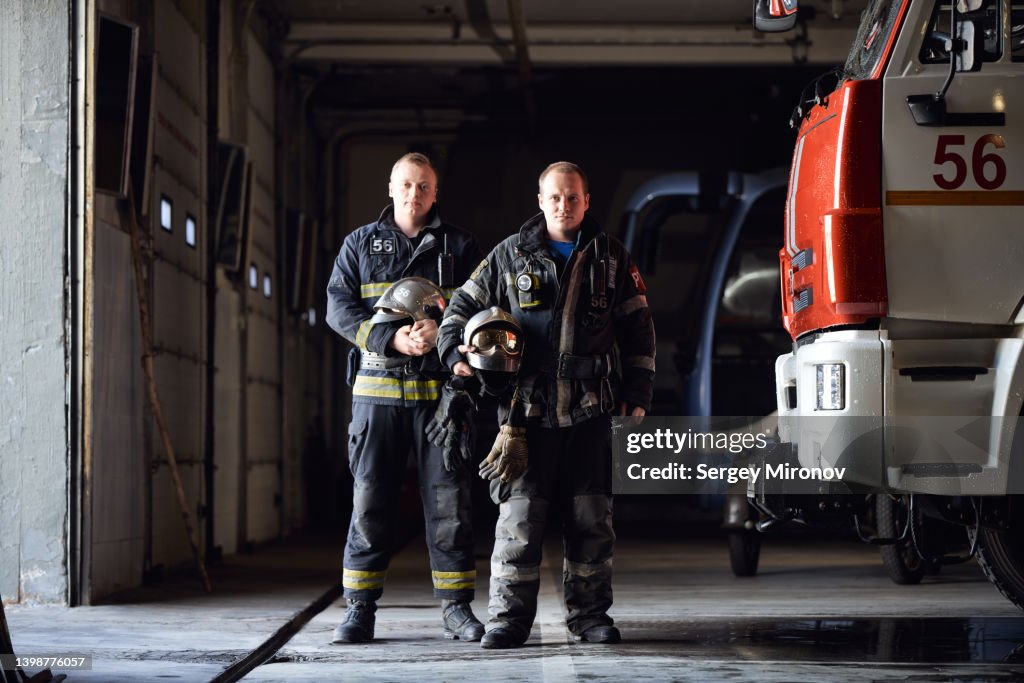 Two firefighters in truck garage
