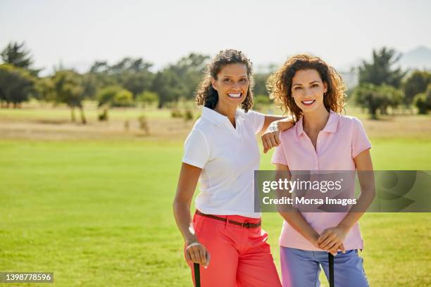 portrait of smiling golfers standing on sports field - golfer stock pictures, royalty-free photos & images