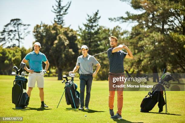 golfers practicing at golf course in summer - arms akimbo ストックフォトと画像