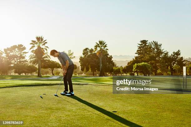 man practicing golf on sunny day - golf pro stock pictures, royalty-free photos & images
