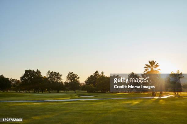 golf course against sky during sunny day - mazza da golf foto e immagini stock