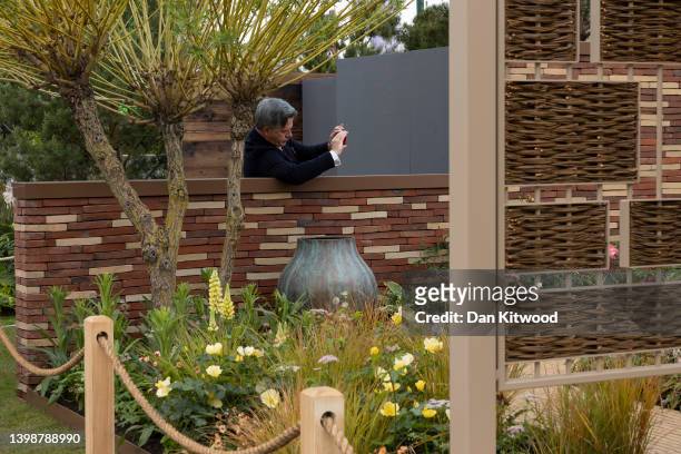 Man takes a photograph of the 'Stitchers' garden at Chelsea Flower Show on May 23, 2022 in London, England. The Chelsea Flower Show returns to its...