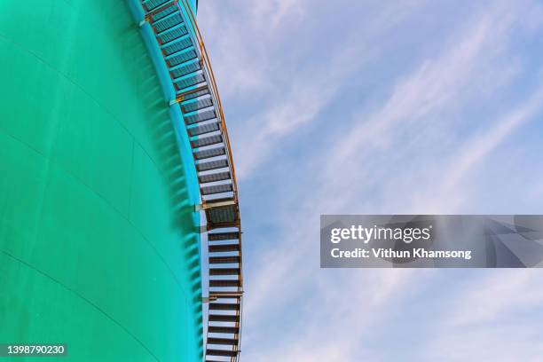 water tank and stair with sky at factory, steel tank of power plant at industrial zone. big industrial oil tanks at refinery. - fuel storage tank stock-fotos und bilder