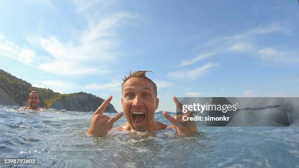 man swimming in sea - rock on bildbanksfoton och bilder