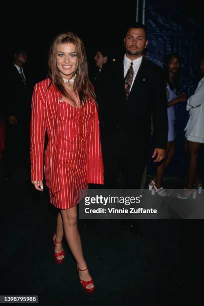 American actress, model and television personality Carmen Electra, wearing a red-and-white striped dress and matching jacket, attends the Universal...