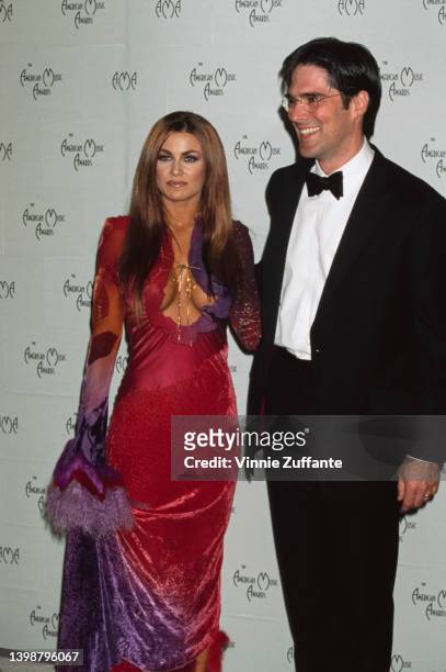American actress, model and television personality Carmen Electra, wearing a red-and-lilac evening gown, and American actor Thomas Gibson in the...