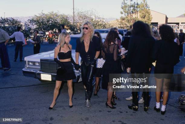American guitarist and songwriter Duff McKagan and his partner, Mandy Brixx, wearing a black bra top, attend the 1989 MTV Video Music Awards, held at...