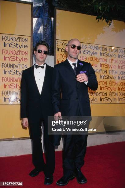 American singer and songwriter Michael Stipe and a man, both wearing sunglasses, attend the Elton John AIDS Foundation and InStyle Oscar Party in Los...