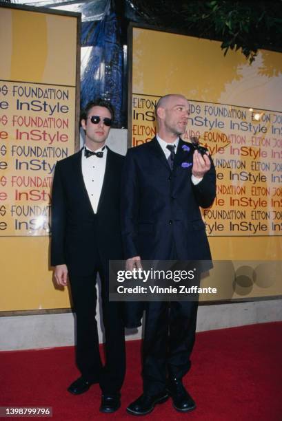 American singer and songwriter Michael Stipe and a man, both wearing sunglasses, attend the Elton John AIDS Foundation and InStyle Oscar Party in Los...