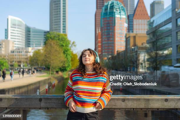 woman listening to music in headphones in the hague - the hague netherlands stock pictures, royalty-free photos & images