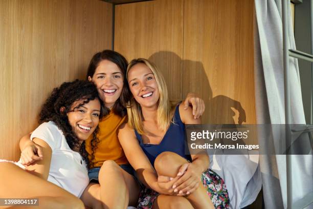 cheerful young female friends in dorm room - bunk beds for 3 stock-fotos und bilder