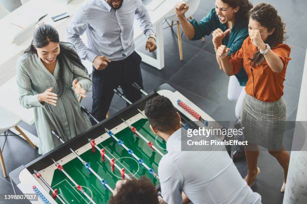 businesspeople playing table football at office - playing board games stock pictures, royalty-free photos & images