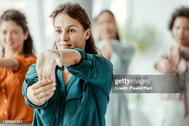 donne d'affari che fanno stretching in ufficio - sport office foto e immagini stock