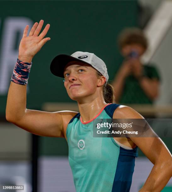 Iga Swiatek of Poland waves to the fans after winning match point during the Women's Singles First Round match against Lesia Tsurenko of Ukraine on...