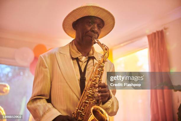 close-up of senior man playing the saxophone. - saxophoniste photos et images de collection