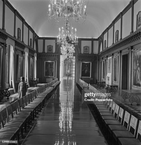 Member of house staff stands behind chairs placed at the long table in the State Dining Room in the Viceroy's House on Rajpath in New Delhi, India...