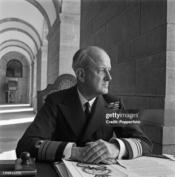 Vice Admiral John Henry Godfrey of the Royal Indian Navy , seated at a desk at RIN headquarters in India during World War II in February 1945.