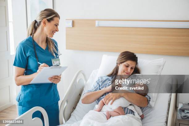 new born baby with his mother at hospital - labor childbirth stockfoto's en -beelden