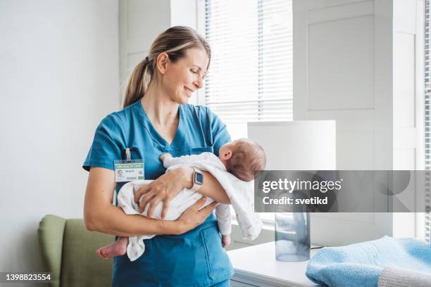 enfermera pediatra que cuida al bebé recién nacido en la sala del hospital. - sala de maternidad fotografías e imágenes de stock