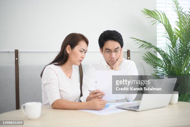 asian couple calculating their monthly expenses - married money stock pictures, royalty-free photos & images