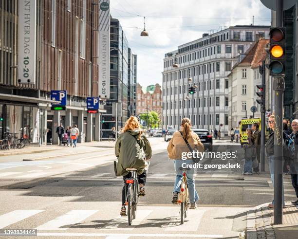 cyclists in copenhagen passing an intersection - pedestrian car stock pictures, royalty-free photos & images