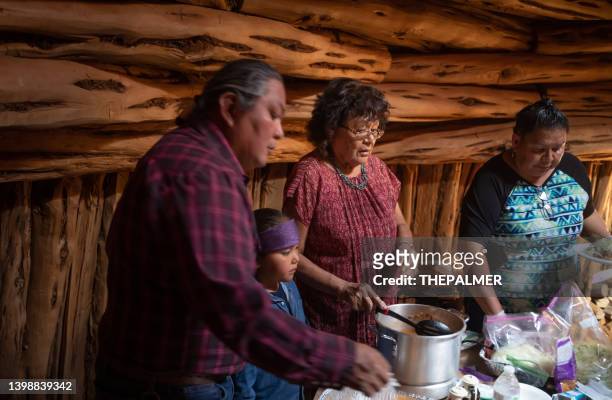 ホーガン内のゲストに伝統的なナバホタコスディナーを提供する家族 - chili woman ストックフォトと画像