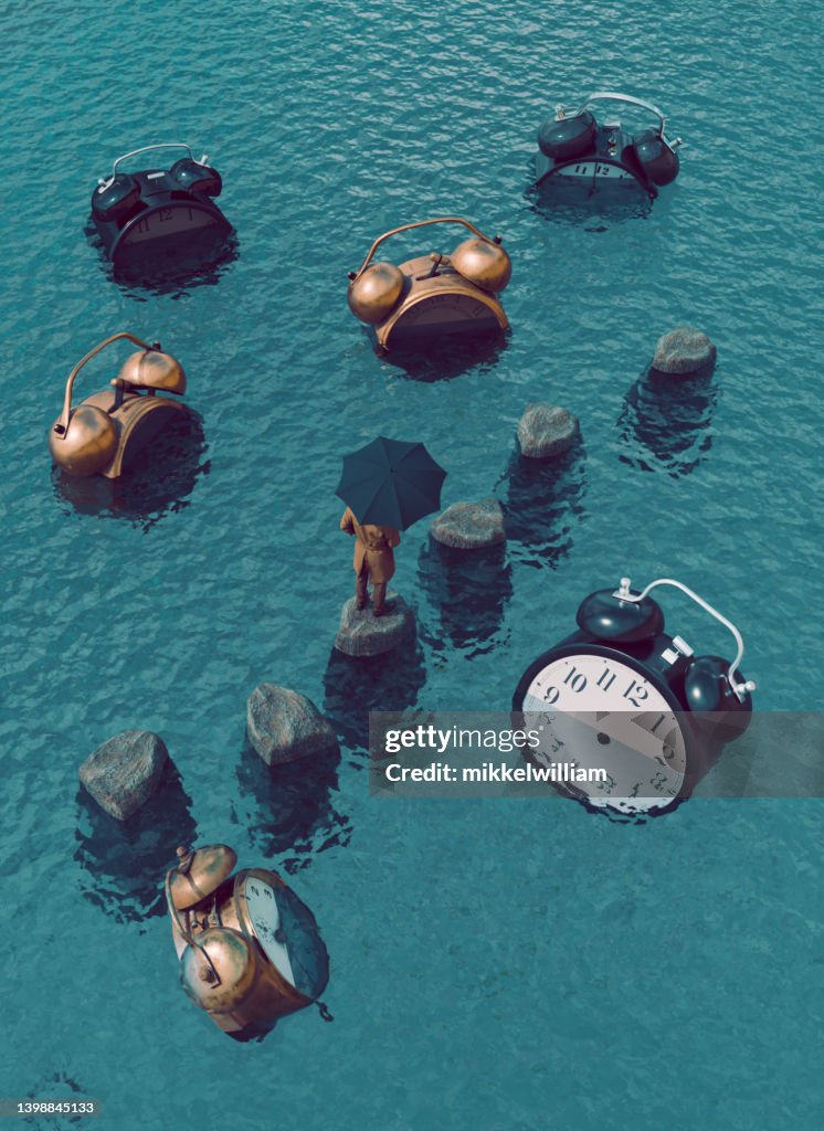Concept image of time illustrated with big alarm clocks trapped in the sea