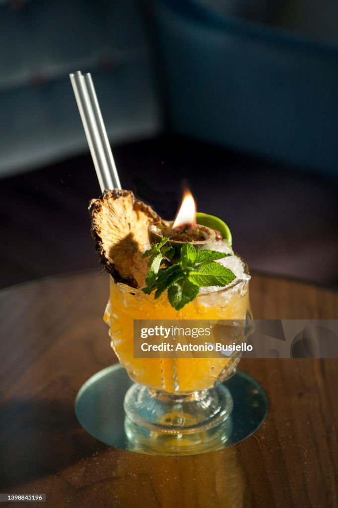 Yellow cocktail with dry pineapple and mint