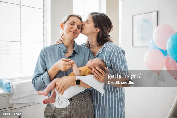 female gay couple with newborn baby - cute lesbian couples stockfoto's en -beelden