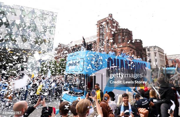 The Manchester City team are seen as the bus parades through the city with the Premier League trophy during the Manchester City FC Victory Parade on...